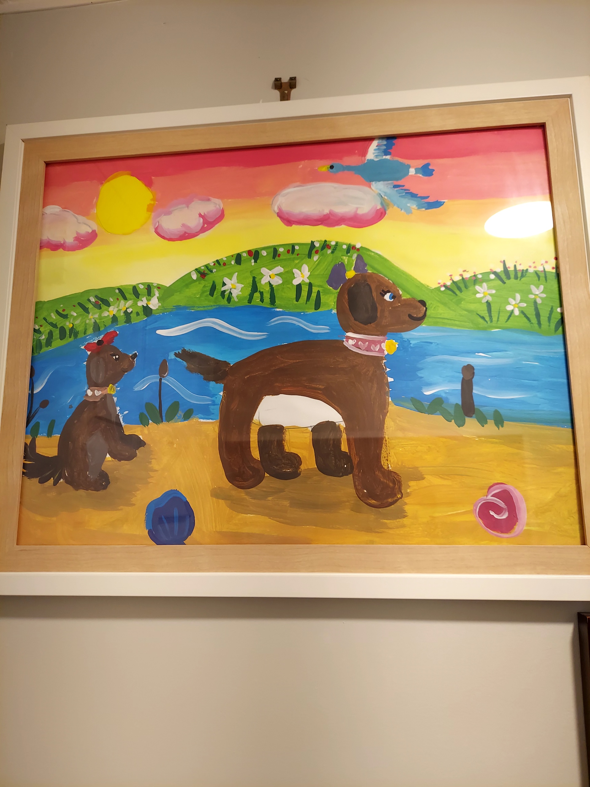 Multiple framed and printed artworks hung together on a warm home wall