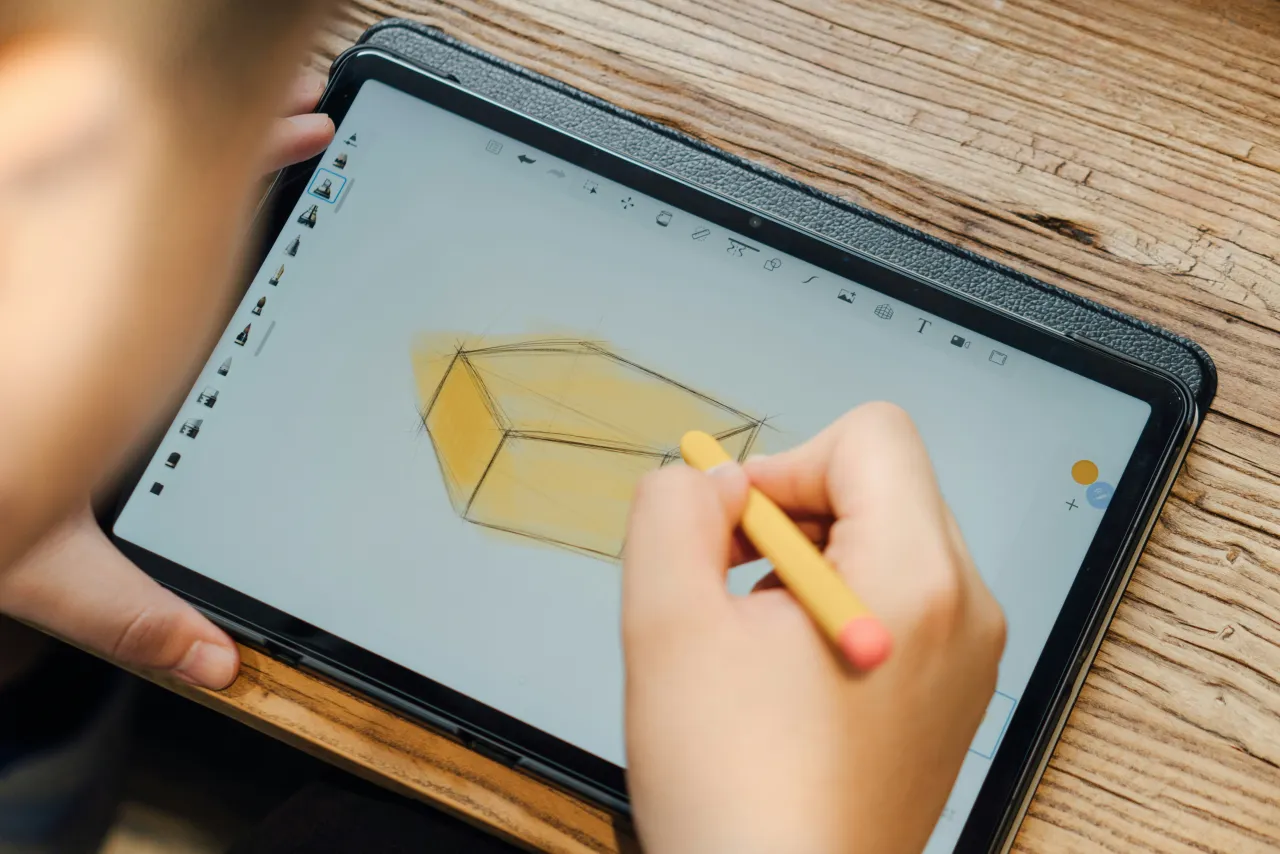 A child drawing on a tablet with a stylus