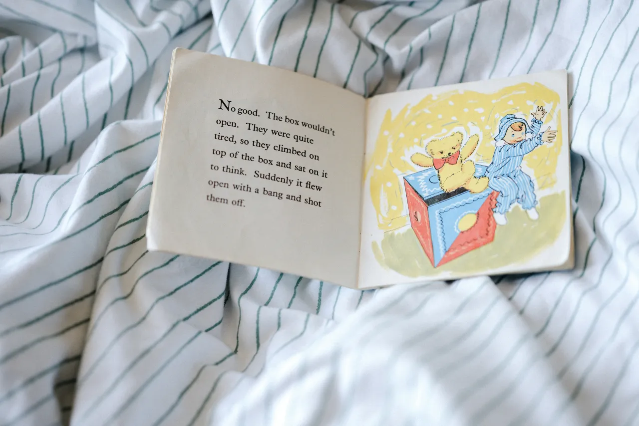 An open illustrated children's picture book showing a teddy bear illustration