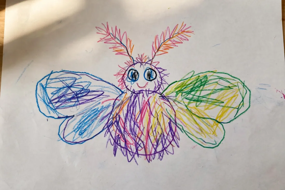 Idris's marker drawing of a round fuzzy moth with wide soft wings and two feathery antennae, used as the hero of his bedtime DoodleTale storybook